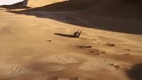 a person riding a motorcycle on top of a sandy beach