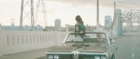 a woman standing on the hood of a car