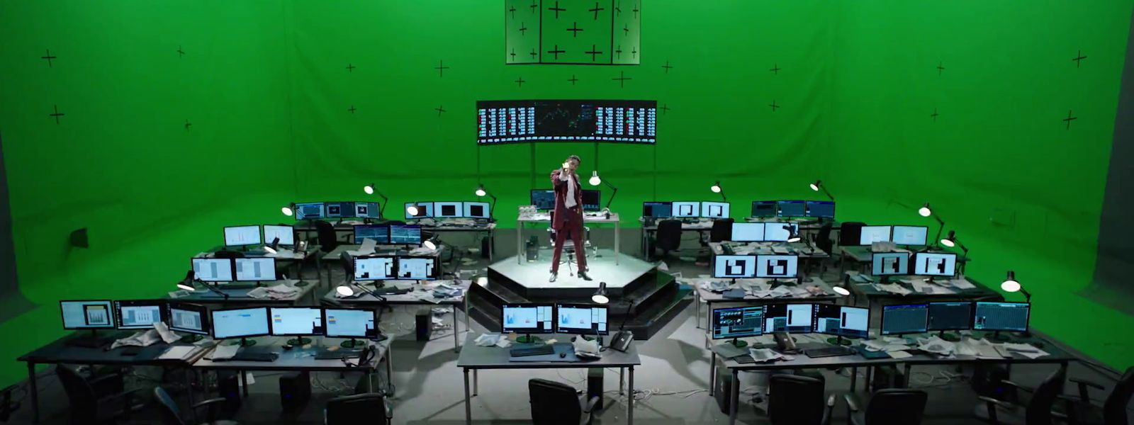 a person standing on a stage surrounded by computer monitors