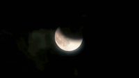 the moon is seen through the clouds in the night sky