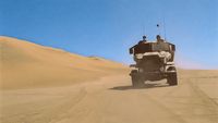 a military vehicle driving through the desert