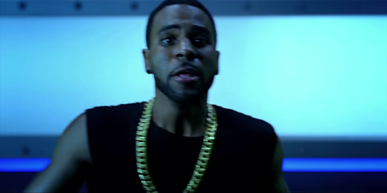 a man in a black shirt wearing a gold chain