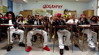 a group of people sitting at desks in a classroom