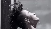 a black and white photo of a woman with her hair blowing in the wind