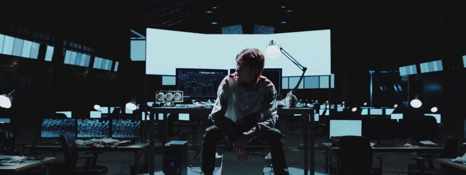 a man sitting on a chair in a dark room