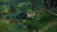 a person laying on the ground in the grass