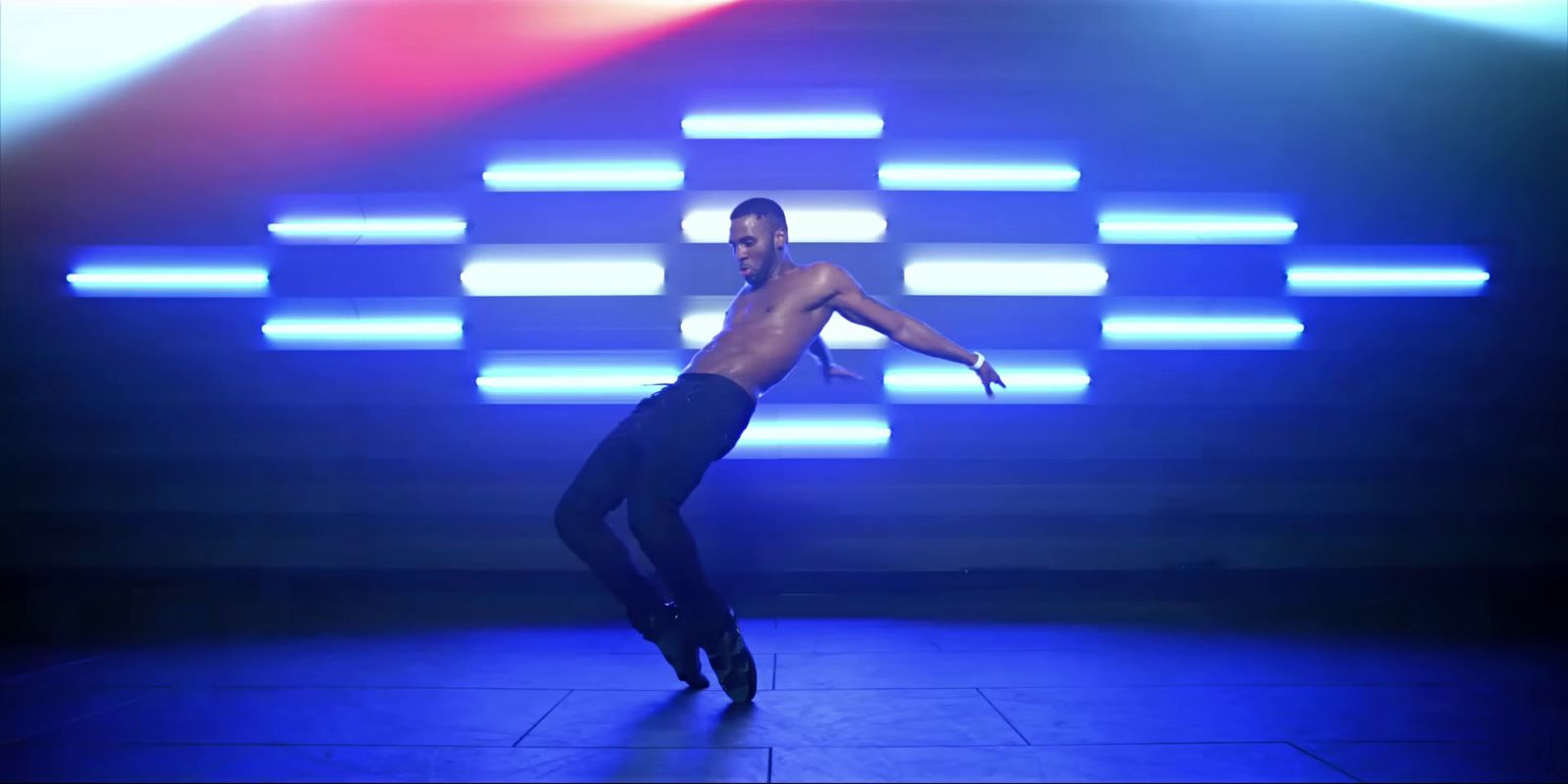 a shirtless man is dancing on a stage