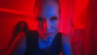 a woman sitting in a room with a red light