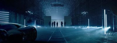 a group of people standing in a dark room next to a car