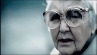 an old woman wearing glasses and a white coat