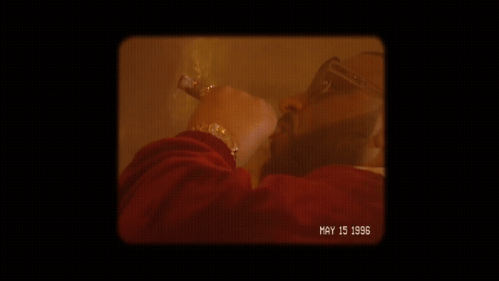 a man in a red shirt drinking from a wine glass