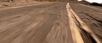 a person riding a skateboard down a desert road