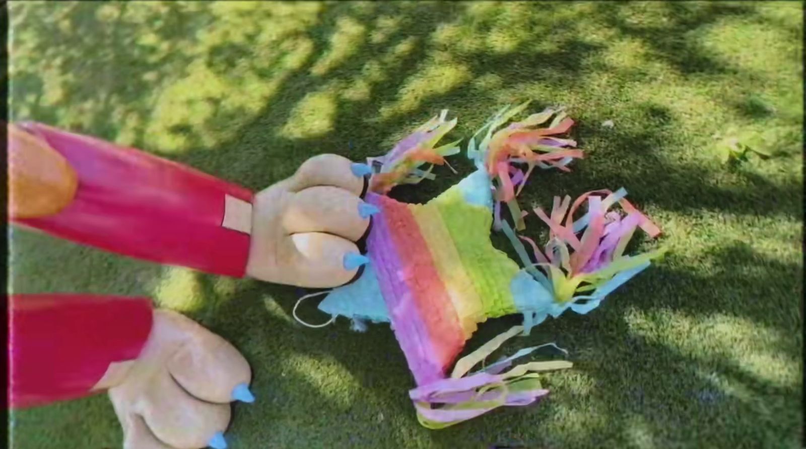 a person holding a colorful kite on top of a lush green field