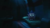 a cartoon character sitting on a pillow in a dark room