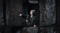 a woman standing in a window of a stone building