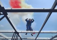 a man in a blue suit standing on a metal structure