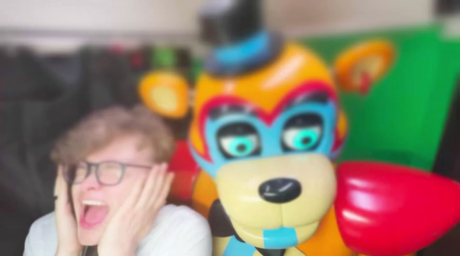 a man in glasses is next to a stuffed animal