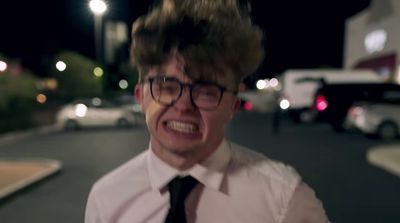 a man wearing glasses and a tie making a face