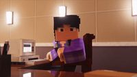 a minecraft man sitting at a desk with a computer