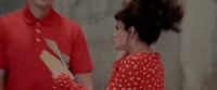 a woman in a red dress standing next to a man in a red shirt