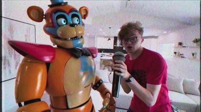 a man holding a microphone next to a cartoon character