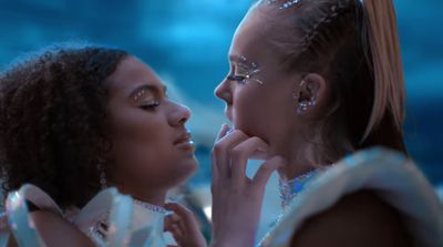 two women in white dresses are looking at each other