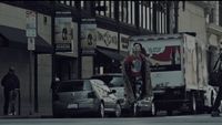 a woman walking across a street next to a truck