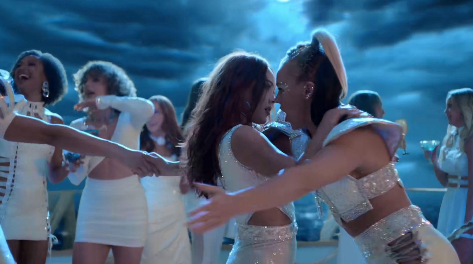 a group of women in white dresses dancing together