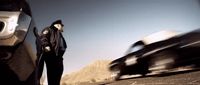 a man standing next to a car on a road