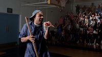 a man holding a baseball bat in a gym