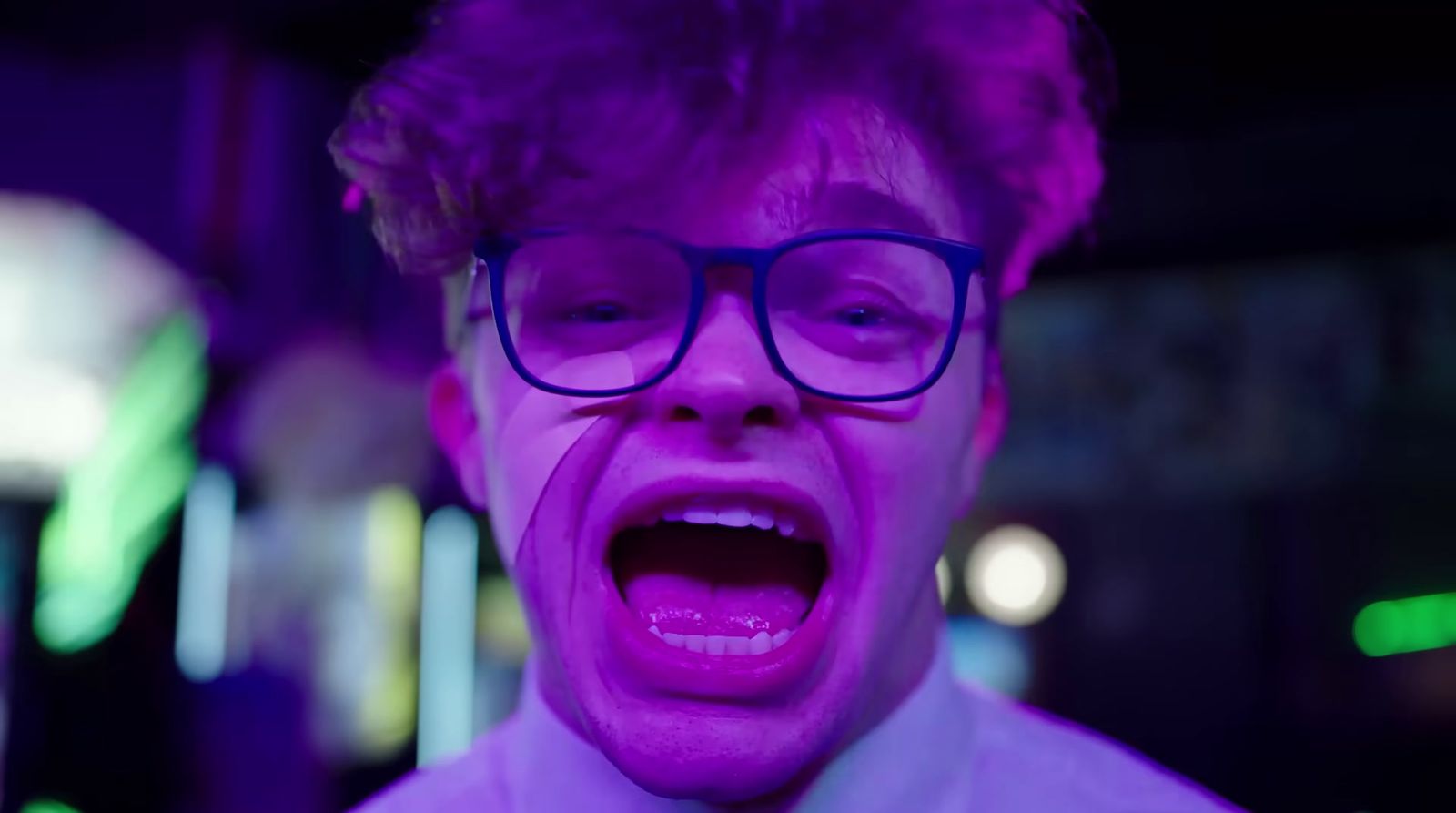 a man with glasses making a face with his mouth open