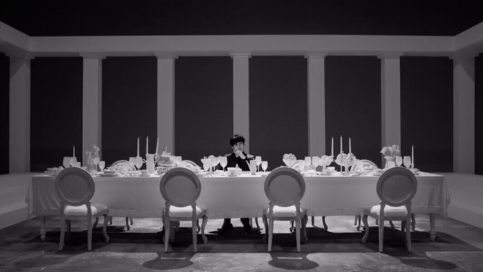 a person sitting at a table with a lot of chairs