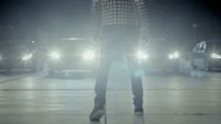 a man standing in the middle of a parking lot at night