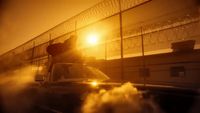 a car driving down a road next to a fence