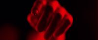 a blurry image of a red hand pointing at something