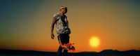 a man riding a skateboard on top of a sandy beach