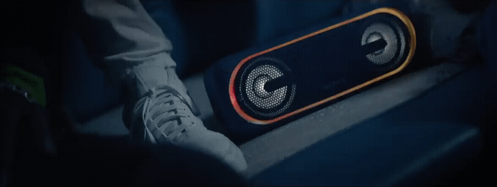a person is sitting on a bench with a speaker