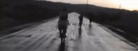 a blurry image of three people walking down a road