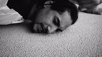 a black and white photo of a man laying on the floor