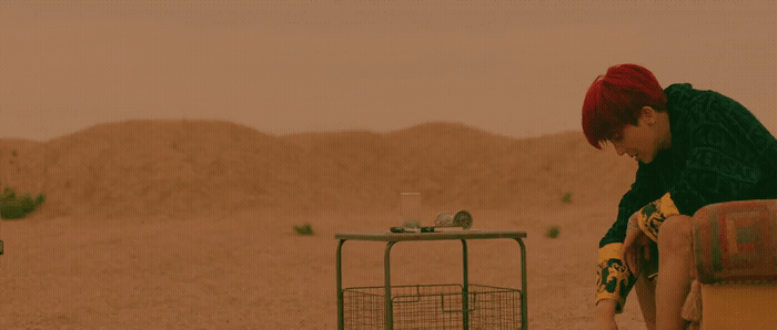 a man sitting on a chair next to a bird cage