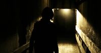 a person is walking down a dark hallway