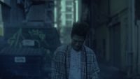 a man walking down a street next to a dumpster