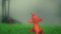 a blurry photo of a red teddy bear in a field