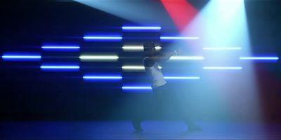 a woman standing in front of a blue and white light