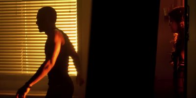 a man standing in front of a window in the dark