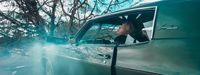 a woman sitting in a car looking out the window