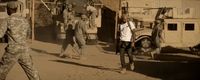 a group of men walking down a dirt road