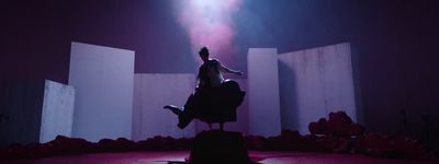 a man standing on top of a chair on a stage