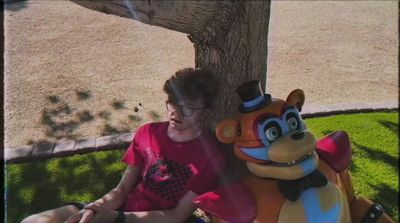 a woman sitting next to a large stuffed animal