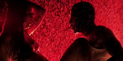 a man and a woman standing under a red light